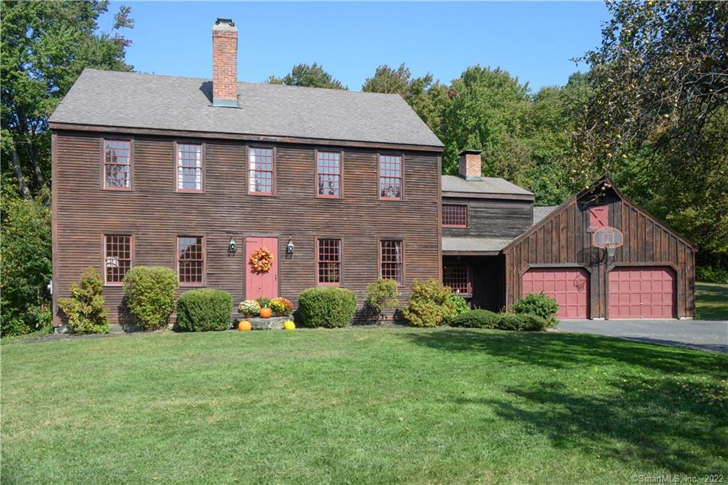 a front view of a house with a yard and trees