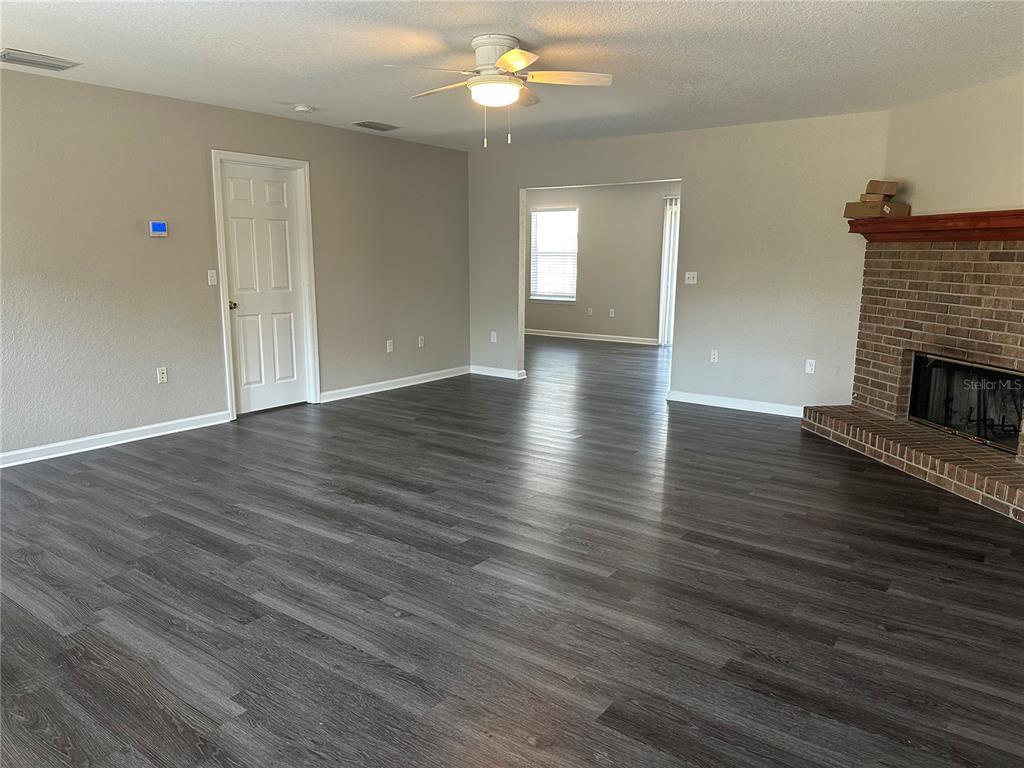 17236 3rd Street Montverde, FL 34756 - Photo 4 of 29 an empty room with wooden floor fireplace and windows