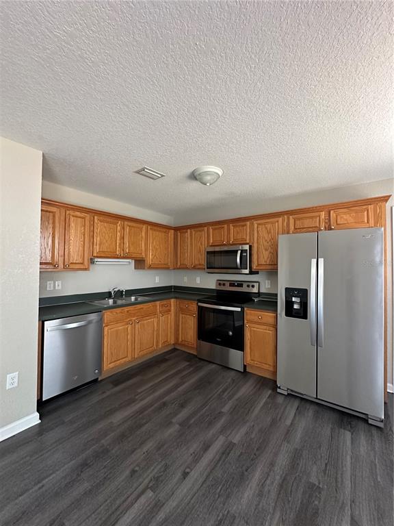 17236 3rd Street Montverde, FL 34756 - Photo 6 of 29 a kitchen with granite countertop a refrigerator and wooden floor