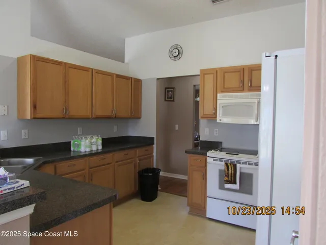 a kitchen with a refrigerator and a stove top oven