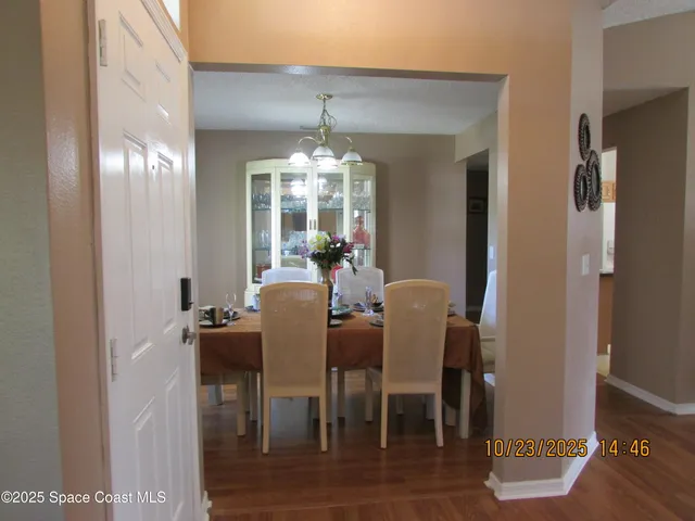 a view of a dining room with furniture and chandelier