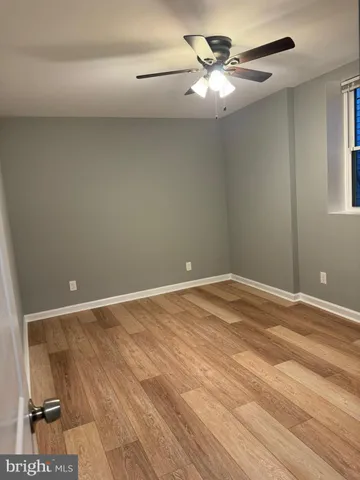 a view of a room with a ceiling fan and wooden floor
