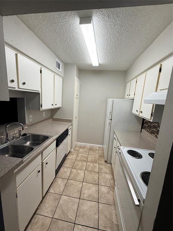 1000 West Spring Valley Road Richardson, TX 75080 - Photo 4 of 7 a kitchen with granite countertop a sink a stove a refrigerator and cabinets