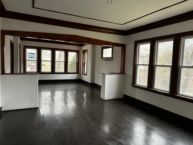 a view of empty room with wooden floor and fan