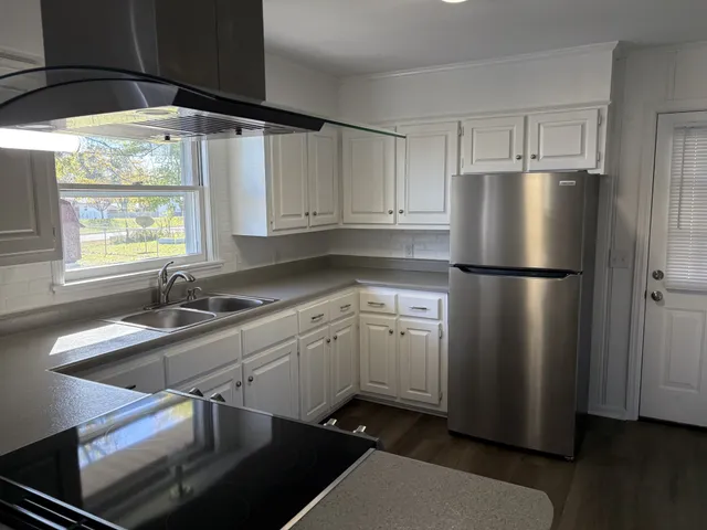 a kitchen with stainless steel appliances granite countertop a sink a refrigerator and a stove