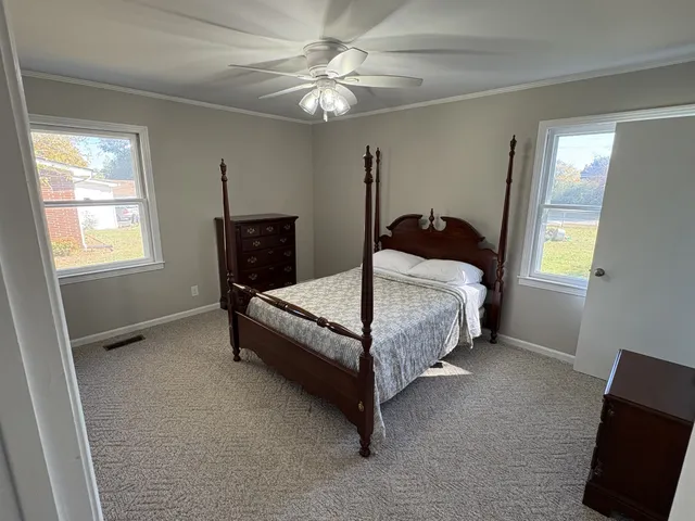 a bedroom with a bed and dresser with mirror