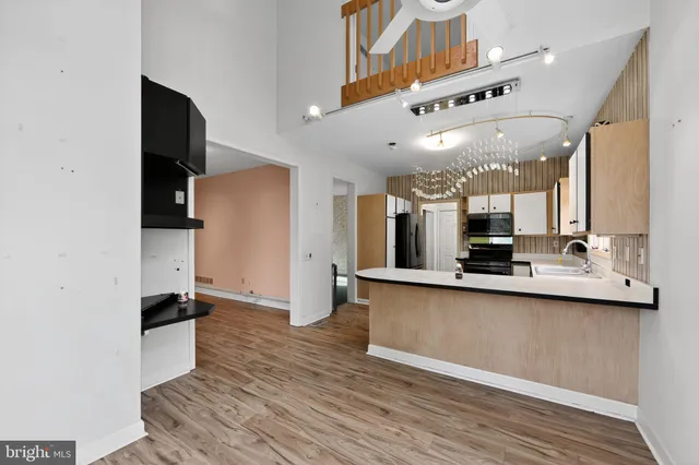 a large white kitchen with a sink and stainless steel appliances