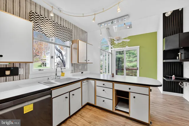 a kitchen with a sink window and cabinets