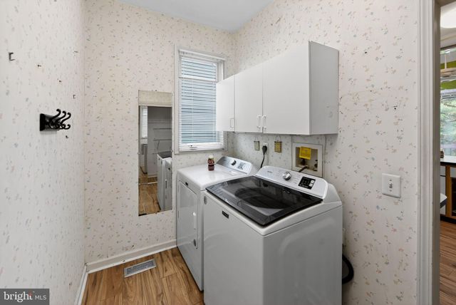 a kitchen that has a sink and a stove with wooden floor