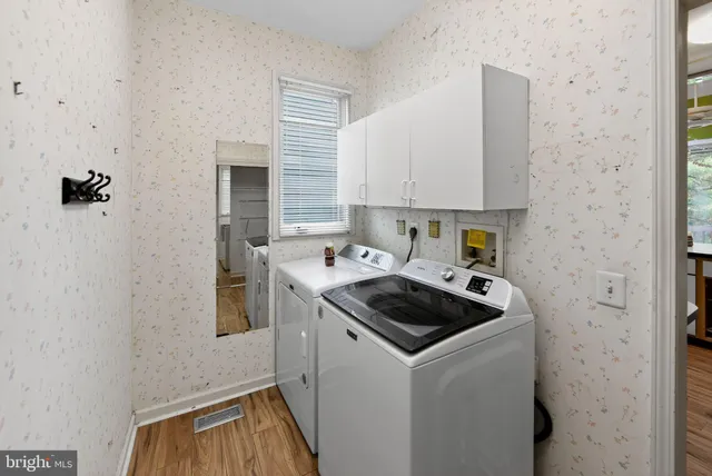 a kitchen that has a sink and a stove with wooden floor