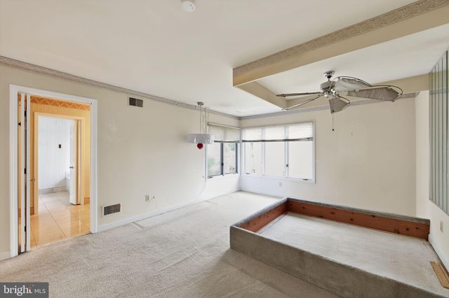a living room with a bed and white walls