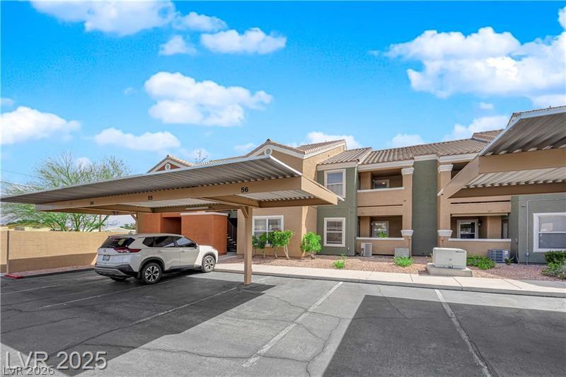 8101 West Flamingo Road, Unit 2030 Las Vegas, NV 89147 - Photo 11 of 27 A tranquil community offers convenient covered parking, complementing the residential units with their distinctive tile roofs and stucco exteriors.