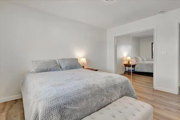 a bedroom with a bed and wooden floor