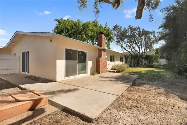 a backyard of a house with table and chairs
