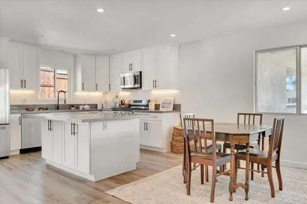 a kitchen with white cabinets chair and center island