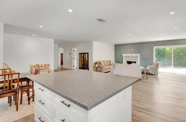 a kitchen with stainless steel appliances granite countertop a table chairs and a refrigerator