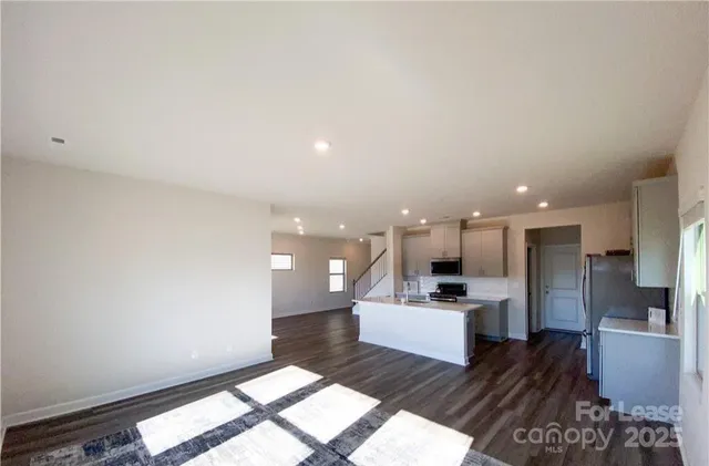 a view of kitchen with refrigerator stove and cabinets