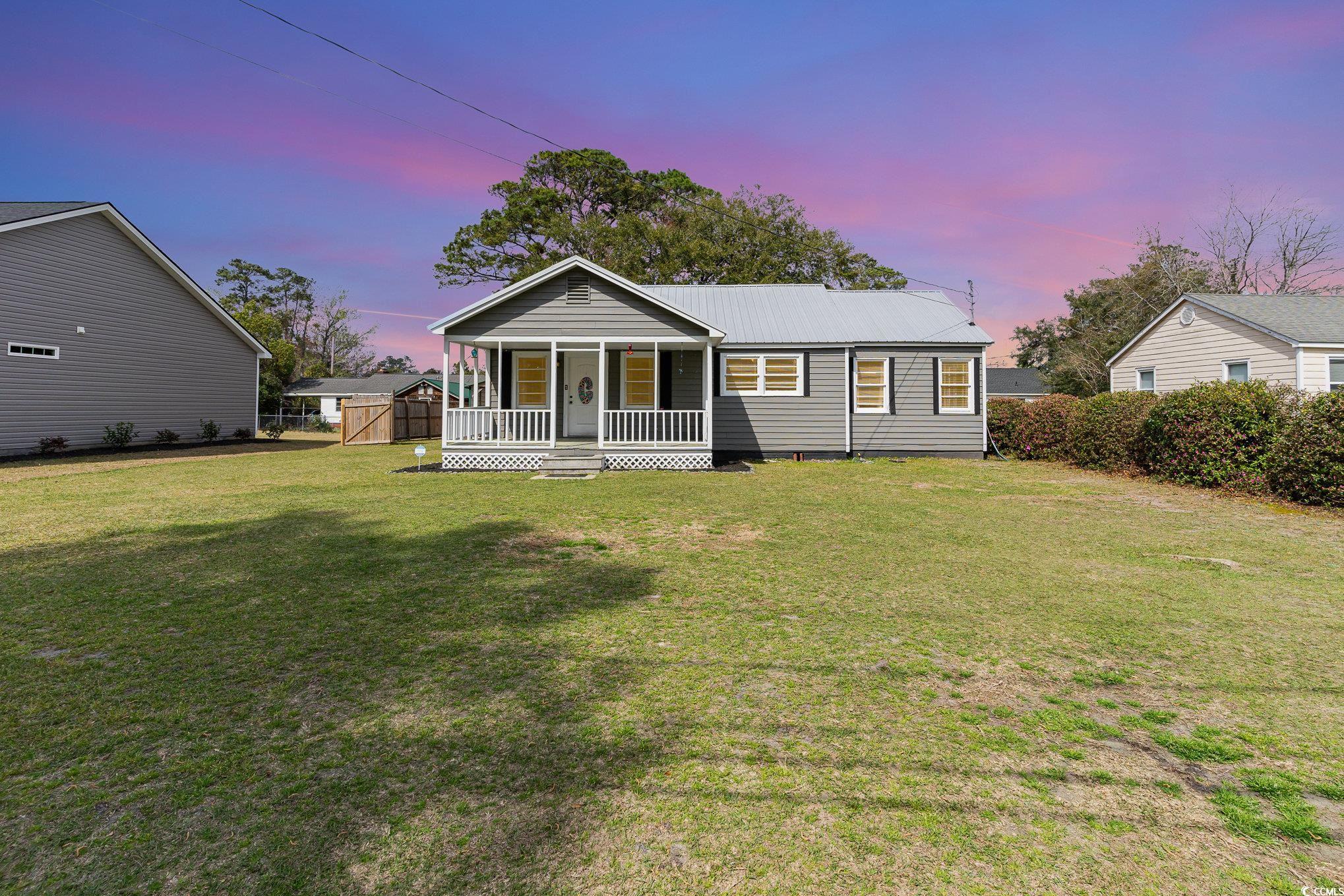 606 Britt Street Georgetown, SC 29440 - Photo 1 of 28 View of front facade with metal roof, a lawn, and