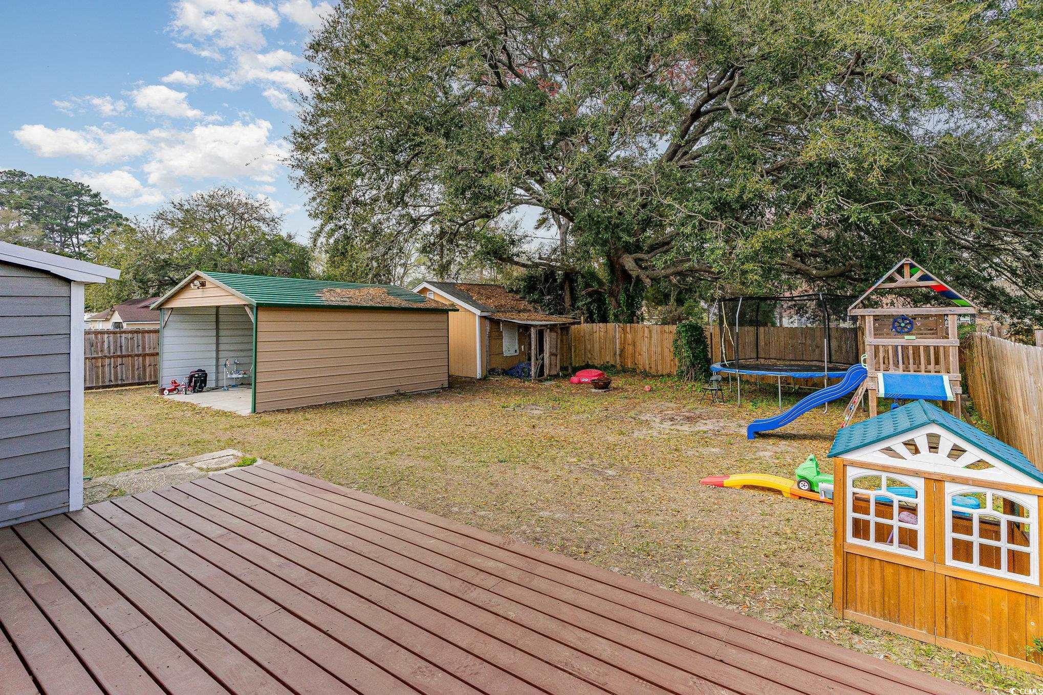 606 Britt Street Georgetown, SC 29440 - Photo 23 of 28 Wooden deck with a trampoline, a fenced backyard,