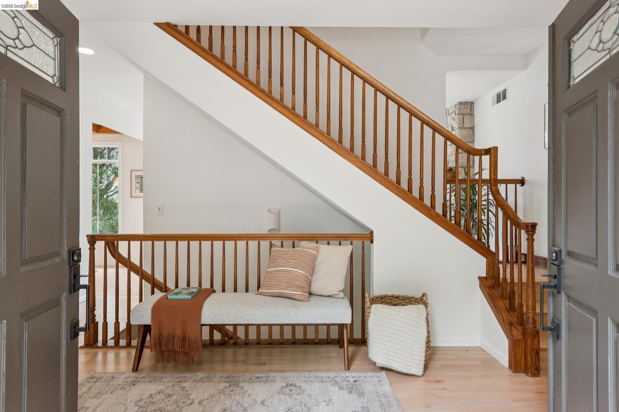1325 Drury Road Berkeley, CA 94705 - Photo 11 of 71 Wood-finish flooring in the entryway with a traditional wood staircase featuring a banister and balusters