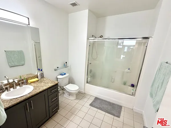 a bathroom with a sink a toilet a mirror and shower