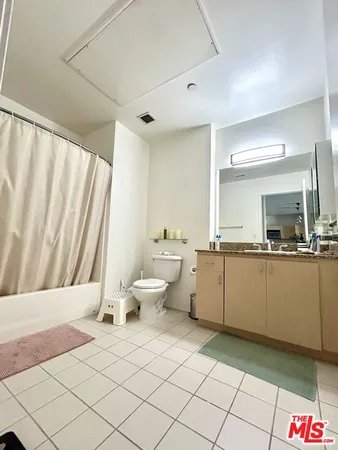 a large white room with a large mirror and sink