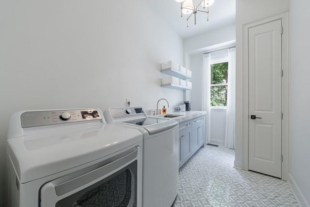 a spacious bedroom with two beds and a chandelier