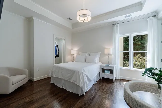 a view of a white house with a big yard and large trees