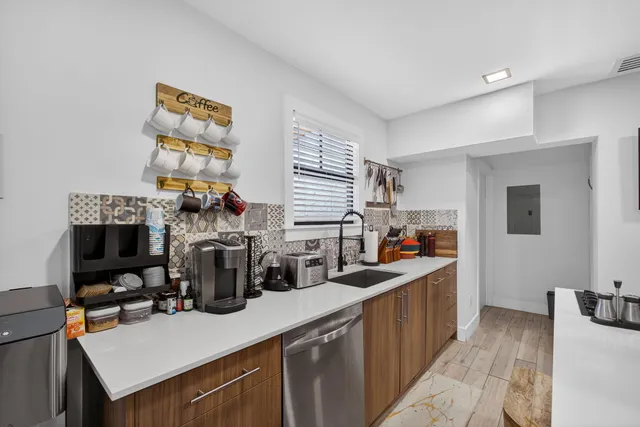 a kitchen with a sink a stove and a dining table with chairs