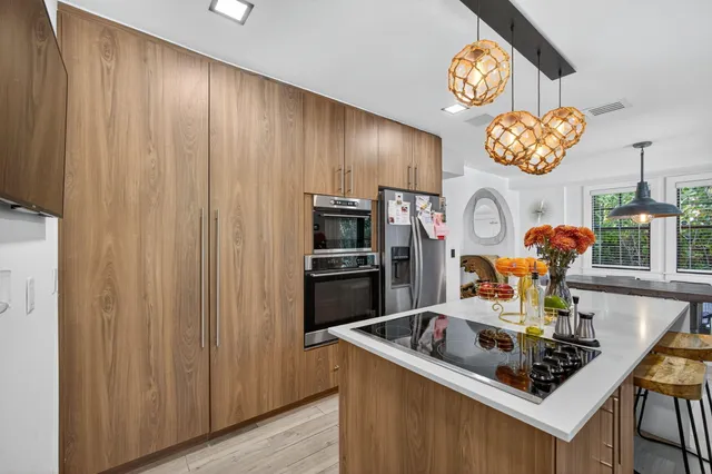 a bathroom with a granite countertop sink a toilet a mirror and window