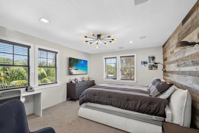 a bedroom with a bed dresser and window