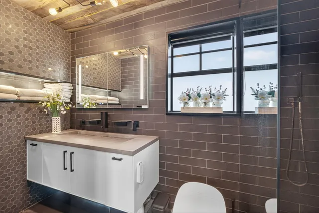 a bathroom with a double vanity sink toilet and shower