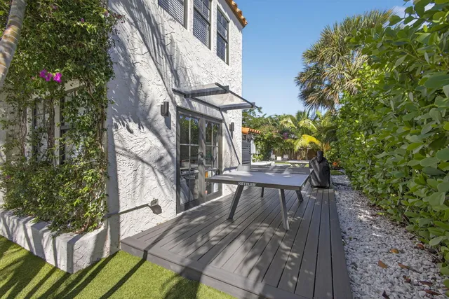 a view of a pool with a table and chairs under an umbrella