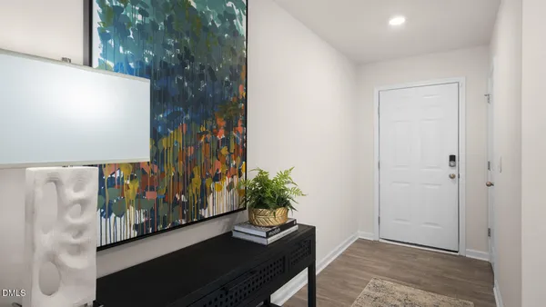 a view of a room with wooden floor and a potted plant