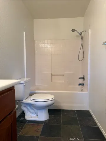 a bathroom with a granite countertop toilet a sink and bathtub