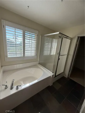 a bathroom with a tub a sink and a window