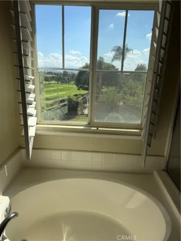 a bathroom with a bathtub and next to a window