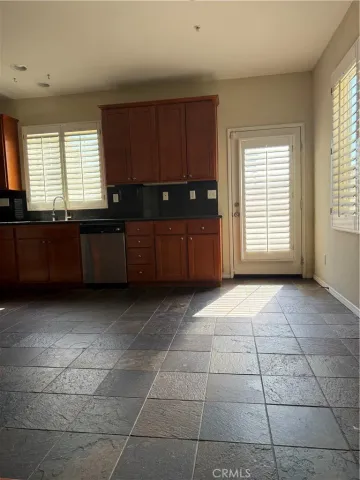 a kitchen with granite countertop a rug a stove a microwave and a window