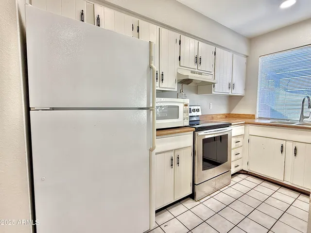 a white refrigerator freezer sitting inside of a kitchen
