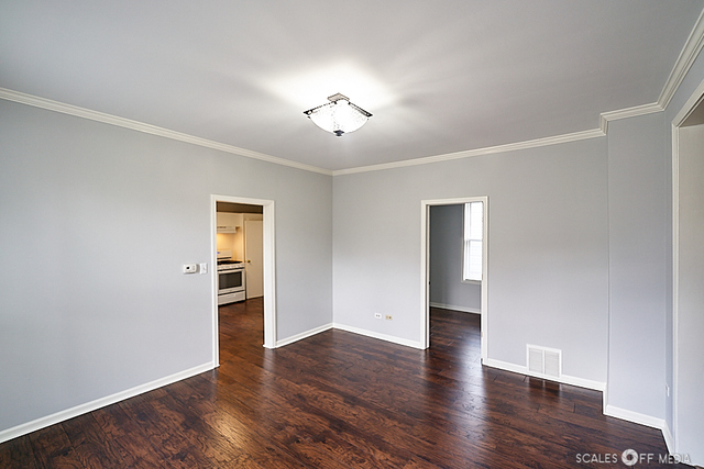 515 Walnut Avenue Elgin, IL 60123 - Photo 4 of 28 an empty room with wooden floor chandelier and windows