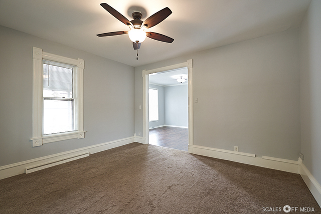 515 Walnut Avenue Elgin, IL 60123 - Photo 7 of 28 an empty room with a empty space and a ceiling fan
