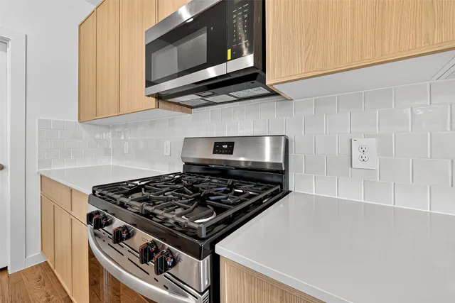 a kitchen with stainless steel appliances a sink stove and cabinets