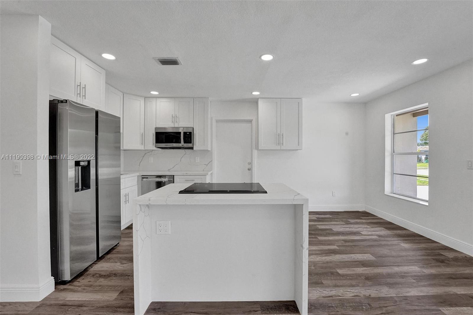 730 Northwest 18th Street Pompano Beach, FL 33060 - Photo 13 of 56 a kitchen with stainless steel appliances granite countertop a refrigerator a sink and a stove