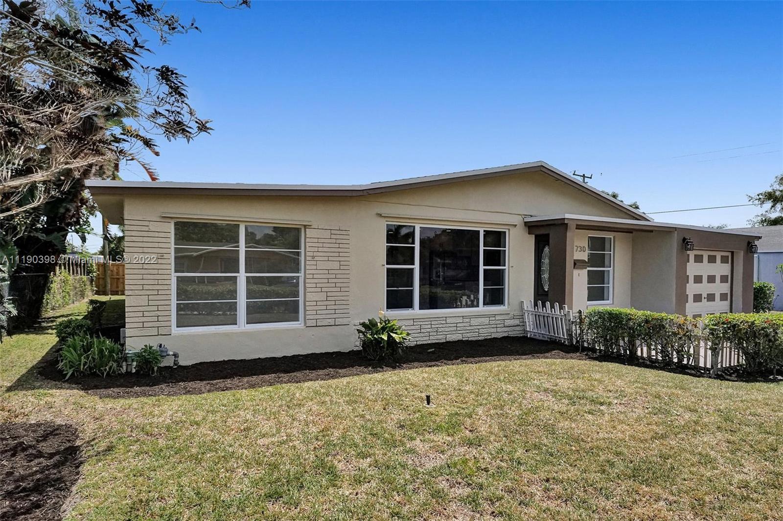 730 Northwest 18th Street Pompano Beach, FL 33060 - Photo 2 of 56 a front view of a house with a garden