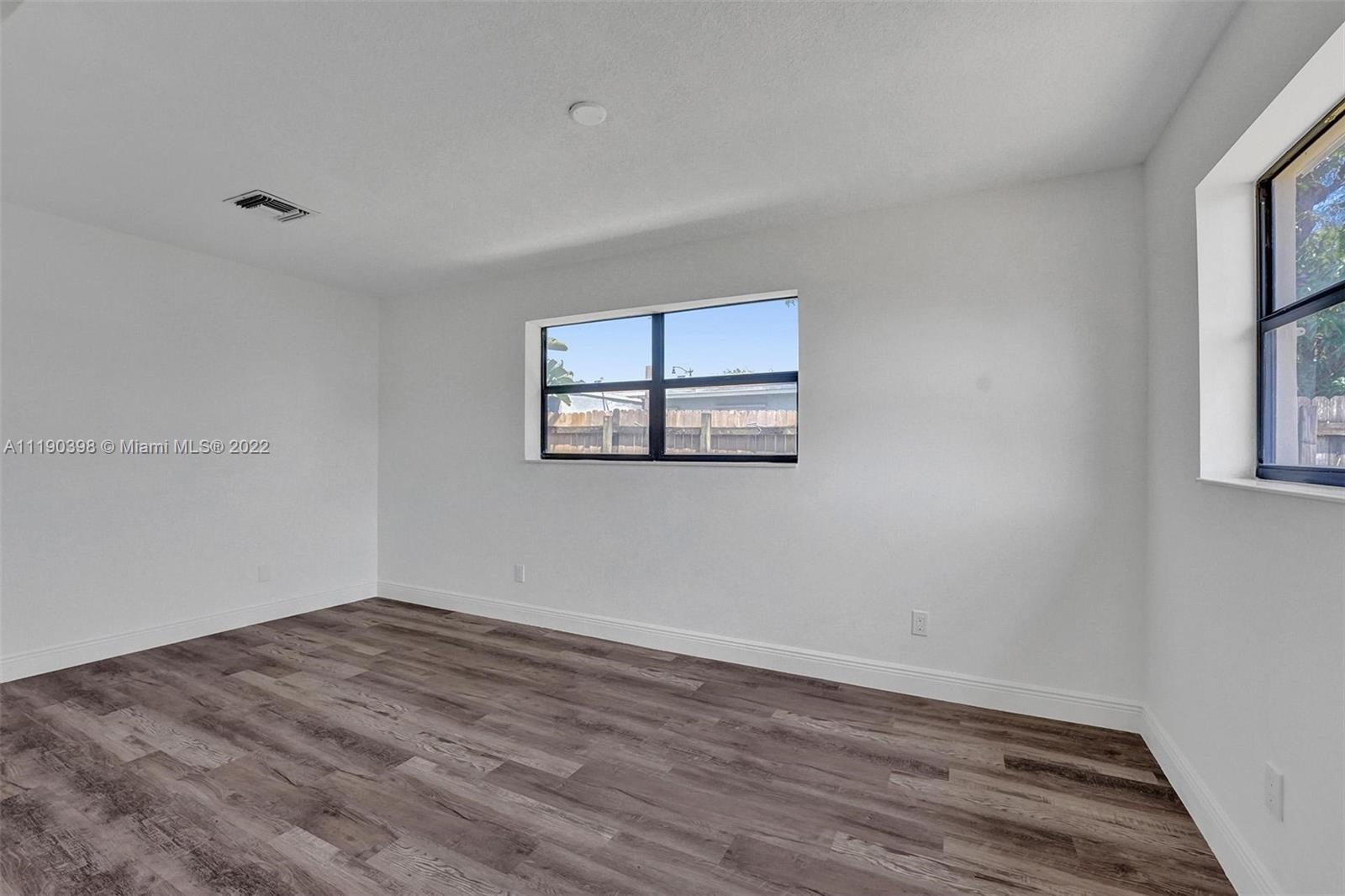 730 Northwest 18th Street Pompano Beach, FL 33060 - Photo 26 of 56 an empty room with wooden floor and windows