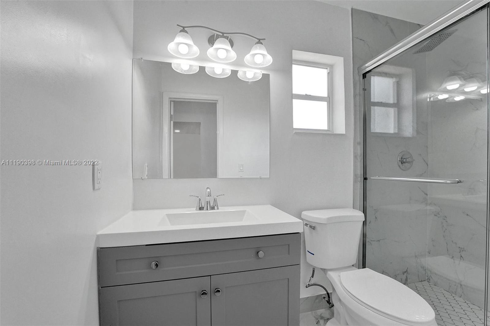 730 Northwest 18th Street Pompano Beach, FL 33060 - Photo 30 of 56 a bathroom with a toilet sink and mirror
