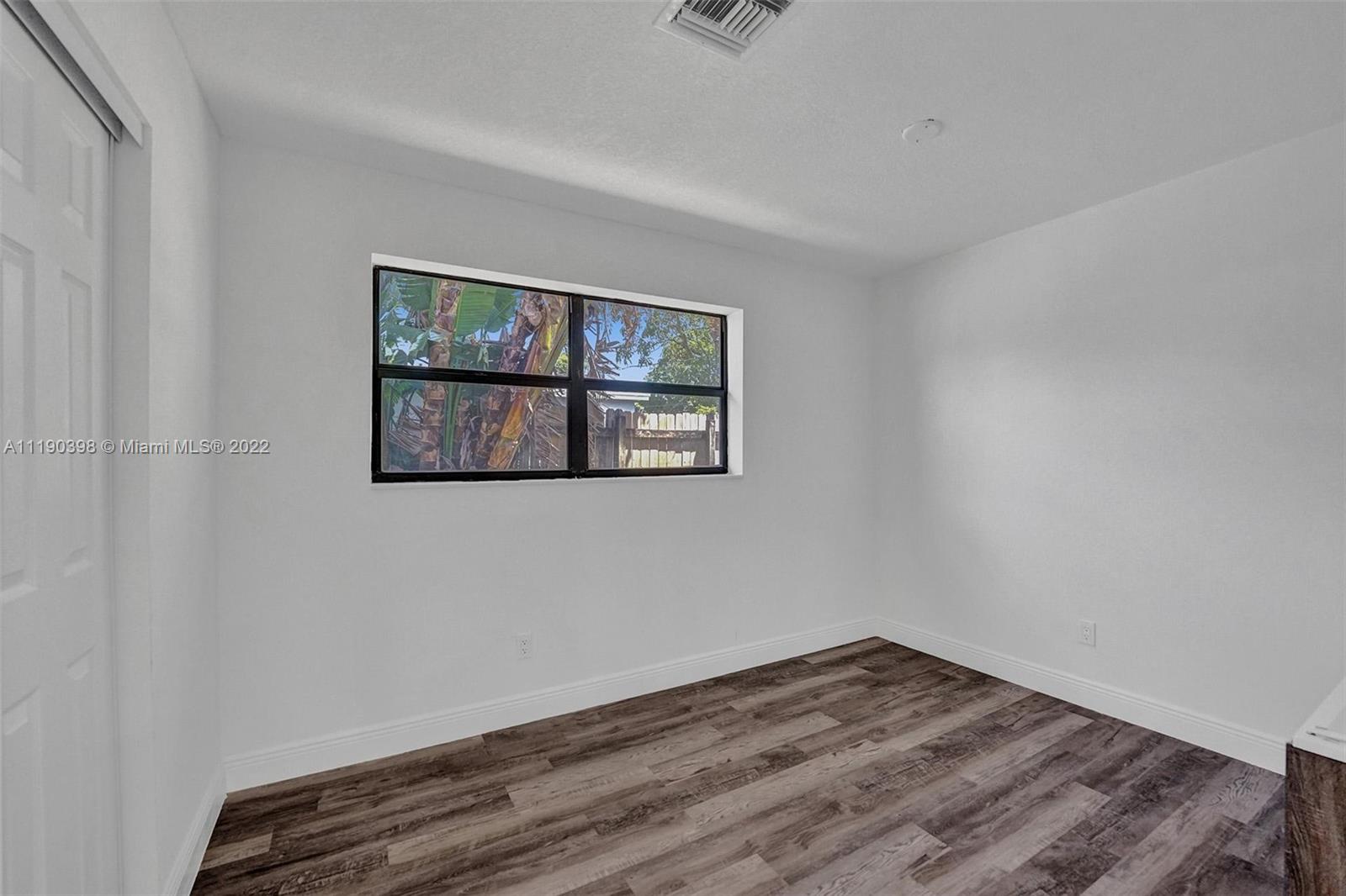 730 Northwest 18th Street Pompano Beach, FL 33060 - Photo 45 of 56 a view of an empty room with wooden floor and window