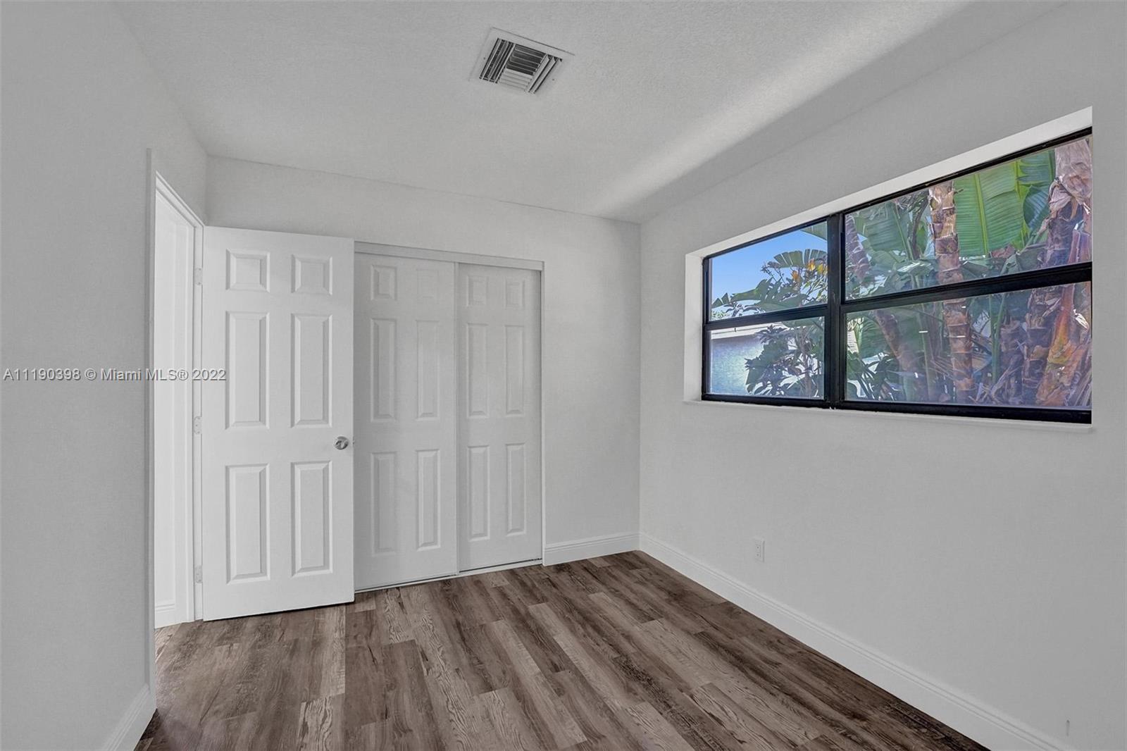 730 Northwest 18th Street Pompano Beach, FL 33060 - Photo 46 of 56 a view of an empty room with wooden floor and a window