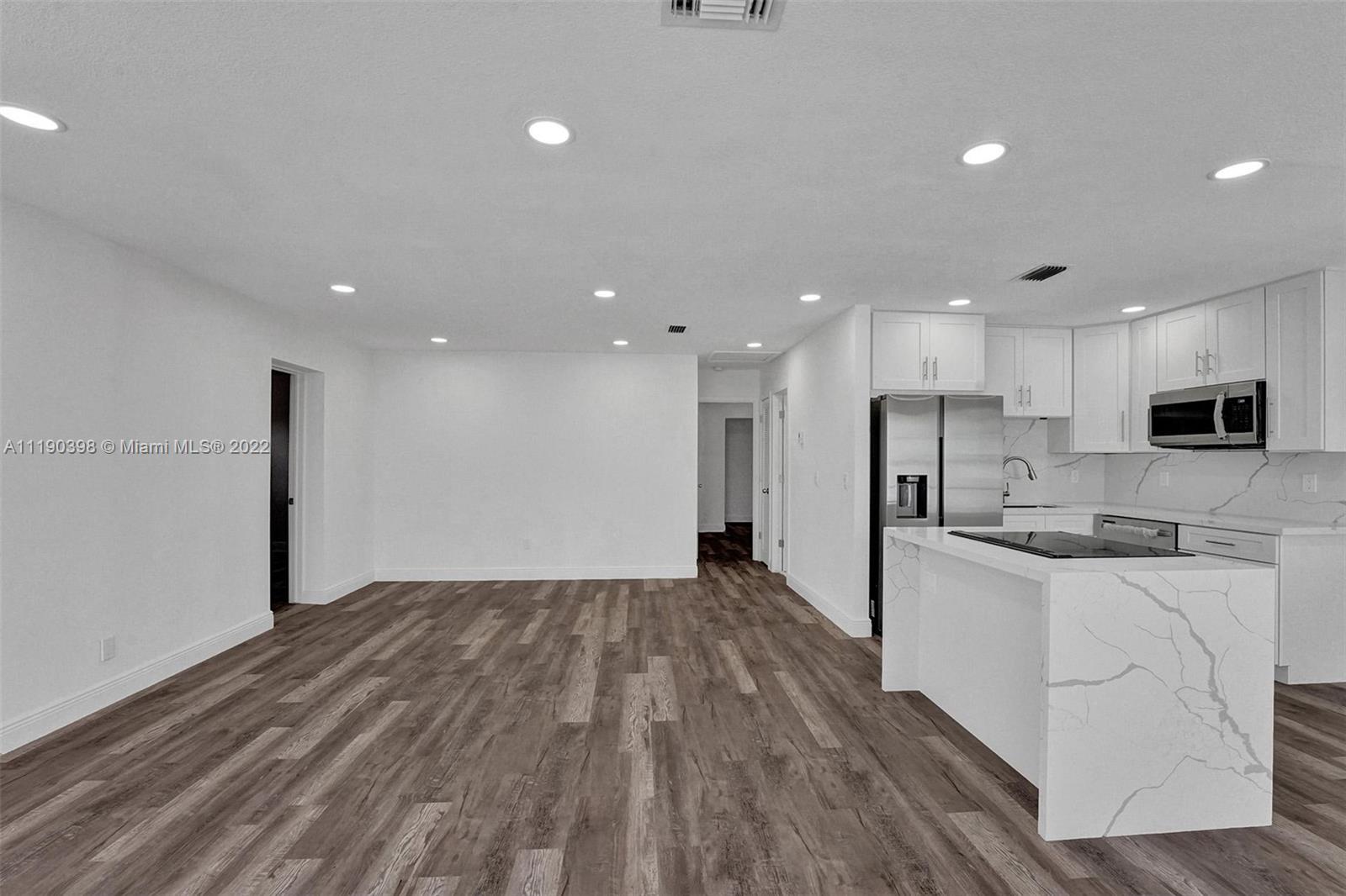 730 Northwest 18th Street Pompano Beach, FL 33060 - Photo 5 of 56 a kitchen with stainless steel appliances granite countertop a sink and a stove top oven