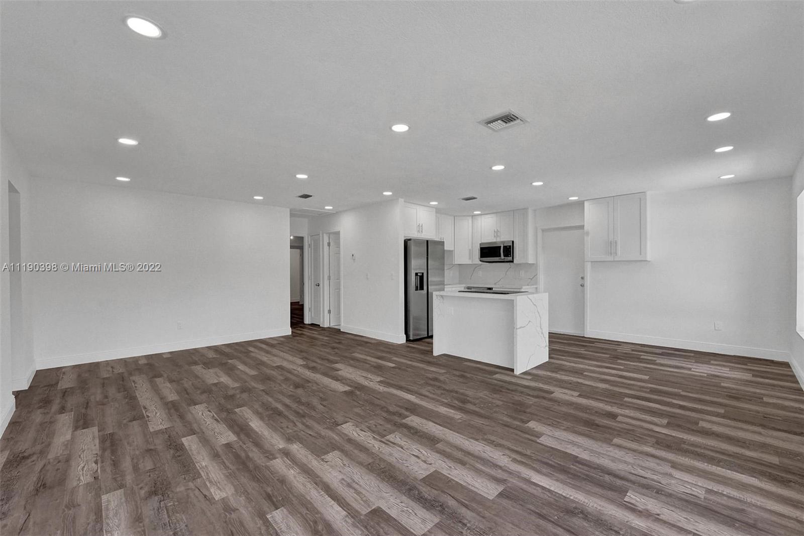 730 Northwest 18th Street Pompano Beach, FL 33060 - Photo 6 of 56 a view of kitchen with kitchen island wooden floor granite top and stainless steel appliances